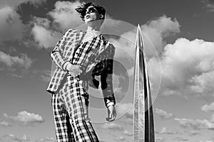 Handsome fashion male model dressed in elegant suit posing outdooe. Long haired Metrosexual. Black and white picture. photo