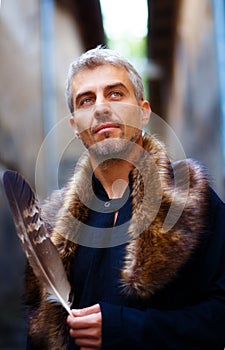 Portrait of a man and wolf furry and eagle feathers, and ornamental medieval window on background