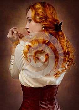 Portrait of a sexy red-haired woman in a skirt, blouse and corset.