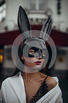 Portrait of sexy woman in mask of Easter bunny and white shirt