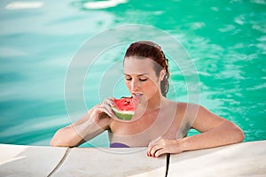 Portrait of woman with piece of watermelon on pool