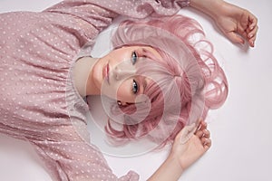 Portrait of a sexy young woman with pink hair. Perfect hairstyle and hair coloring. Girl with beautiful blue eyes and long pink