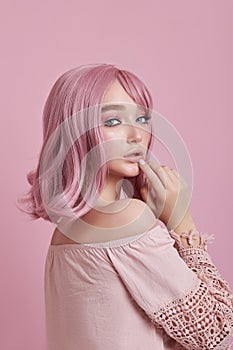 Portrait of a sexy young woman with pink hair. Perfect hairstyle and hair coloring. Girl with beautiful blue eyes and long pink