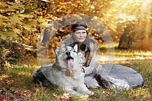 Portrait of a Shaman woman with an Alaskan Malamute dog in the forest