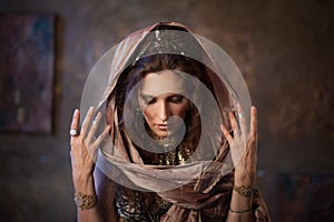 Portrait in the shawl. Tribal dancer, beautiful woman in the ethnic style on a textured background