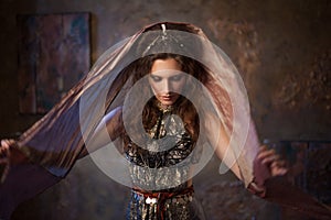 Portrait in the shawl. Tribal dancer, beautiful woman in the ethnic style on a textured background