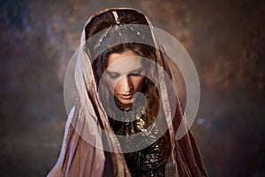 Portrait in the shawl. Tribal dancer, beautiful woman in the ethnic style on a textured background