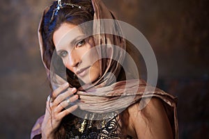 Portrait in the shawl. Tribal dancer, beautiful woman in the ethnic style on a textured background