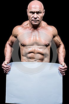 Portrait of shirtless man holding blank paper