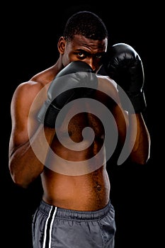 Portrait of a shirtless muscular boxer in defensive stance