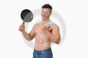 Portrait of a shirtless muscular man holding frying pan