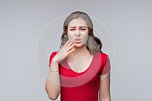 Portrait of shocked afraid woman looking with having wide open mouth gesturing palms, standing gray background