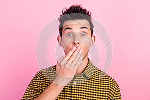 Portrait of shocked amazed young man covering mouth with hands on isolated pastel background in studio