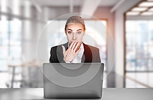 Portrait of shocked attractive business woman in suit sitting at