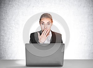 Portrait of shocked attractive business woman in suit sitting at the desk in front of laptop and dreaming about career