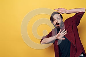 Portrait of Shocked Bearded Man keeps Hands up