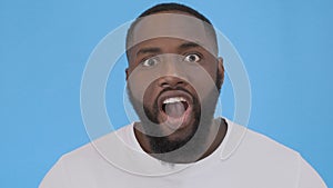 Portrait of shocked black male says wow, looks bugged eyes and rounded mouth, being amazed to see something unexpected
