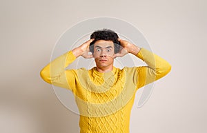 Portrait of shocked businessman with hands in hair looking at camera furiously on white background