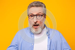 Portrait of shocked emotional senior man with gray hair, studio