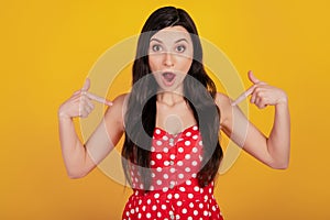 Portrait of shocked excited woman direct finger herself omg reaction wear dotted red dress on yellow background