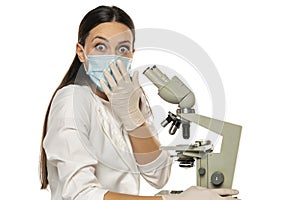 Portrait of shocked female scientist with microscope