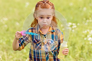 portrait of shocked kid blowing soap bubbles