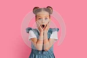 Portrait Of Shocked Little Girl Touching Face And Looking At Camera