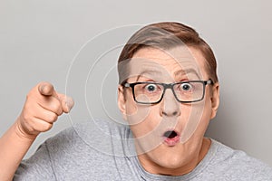 Portrait of shocked man pointing with finger at something unbelievable