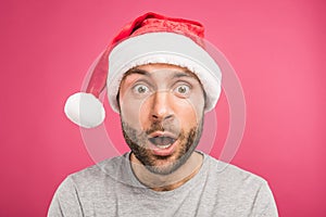 portrait of shocked man in santa hat, isolated