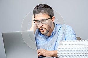 Portrait of shocked man sitting at the table with laptop