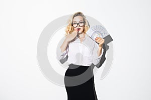 Portrait of a shocked pretty girl holding bunch of money banknotes and covering her mouth isolated over white background