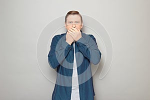 Portrait of shocked stunned mature man covering mouth with hands
