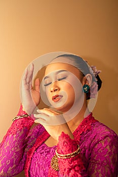 Portrait Shoot of Beautiful Balinese Women Preparing for the praying ritual while wearing pink dresses and gold badges