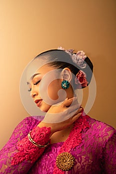 Portrait Shoot of Beautiful Balinese Women Preparing for the praying ritual while wearing pink dresses and gold badges