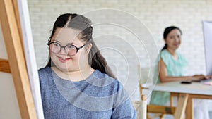 Portrait shot of Asian happy lovely mother standing smiling with young chubby down syndrome autistic autism little daughter