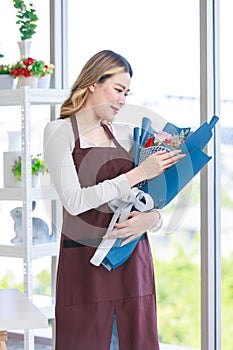 Portrait shot of Asian professional successful female florist designer shop owner entrepreneur businesswoman in apron standing