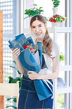 Portrait shot of Asian professional successful female florist designer shop owner entrepreneur businesswoman in apron standing