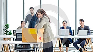 Portrait shot of Asian sad jobless businesswoman in casual suit standing holding belongings in cardboard box after fired while