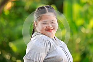 Portrait shot of Asian young chubby down syndrome autistic autism little cute schoolgirl with braid pigtail hairstyle model stand