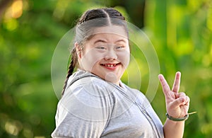 Portrait shot of Asian young chubby down syndrome autistic autism little cute schoolgirl with braid pigtail hairstyle model stand