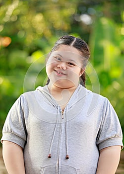 Portrait shot of Asian young chubby down syndrome autistic autism little cute schoolgirl with braid pigtail hairstyle model stand