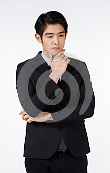 Portrait shot of Asian young handsome happy intelligence successful businessman in black formal suit stand hold hand touch chin