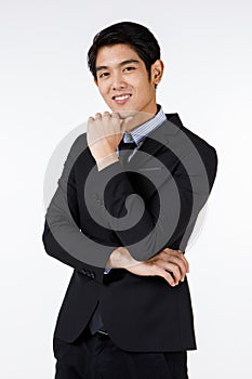 Portrait shot of Asian young handsome happy intelligence successful businessman in black formal suit stand hold hand touch chin