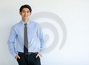 Portrait shot of Asian young happy business office worker wears blue stripe long sleeve shirt standing smiling lean on wall put