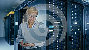 Portrait Shot In Data Center: Female IT Technician Running Maintenance Programme on a Laptop, Cont