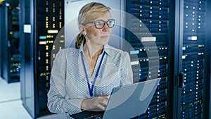 Portrait Shot In Data Center: Female IT Technician Running Maintenance Programme on a Laptop, Cont