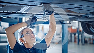 Portrait Shot of a Female Mechanic Working on a Vehicle in a Car Service. Empowering Woman Wearing