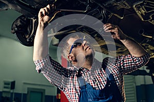 Portrait Shot of a Handsome Mechanic Working on a Vehicle in a Car Service