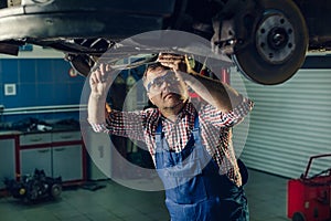 Portrait Shot of a Handsome Mechanic Working on a Vehicle in a Car Service