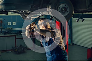 Portrait Shot of a Handsome Mechanic Working on a Vehicle in a Car Service